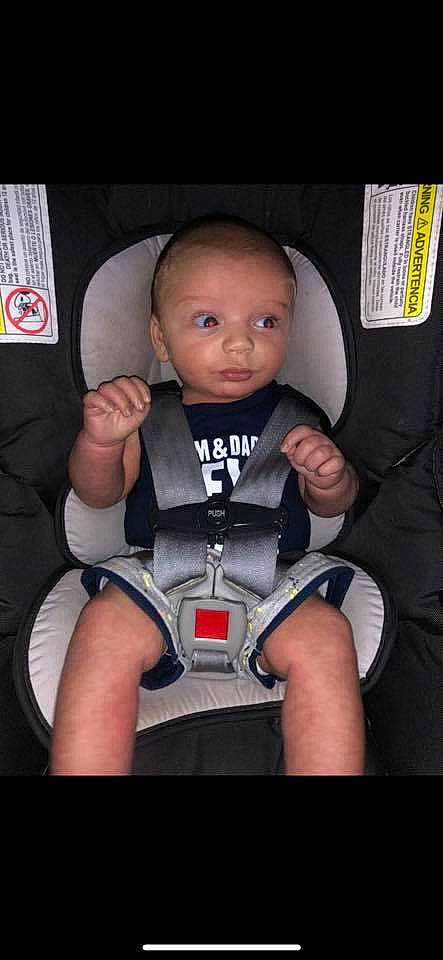 Ricky is registered to the contest to win money with this photo: baby, baby_carriage, baby_toddler_clothing, car_seat, cheek, child, comfort, finger, flash_photography, fun, human_leg, joint, knee, person, product, seat_belt, sitting, thigh, thumb, toddler