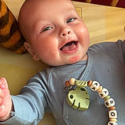 Aaron participe au concours pour gagner de l'argent avec cette photo : baby, beads, bedding, blue_clothing, child, closeup, crib, cute, expression, face, hand, happy, indoors, infant, playful, portrait, skin, smiling, toy, young