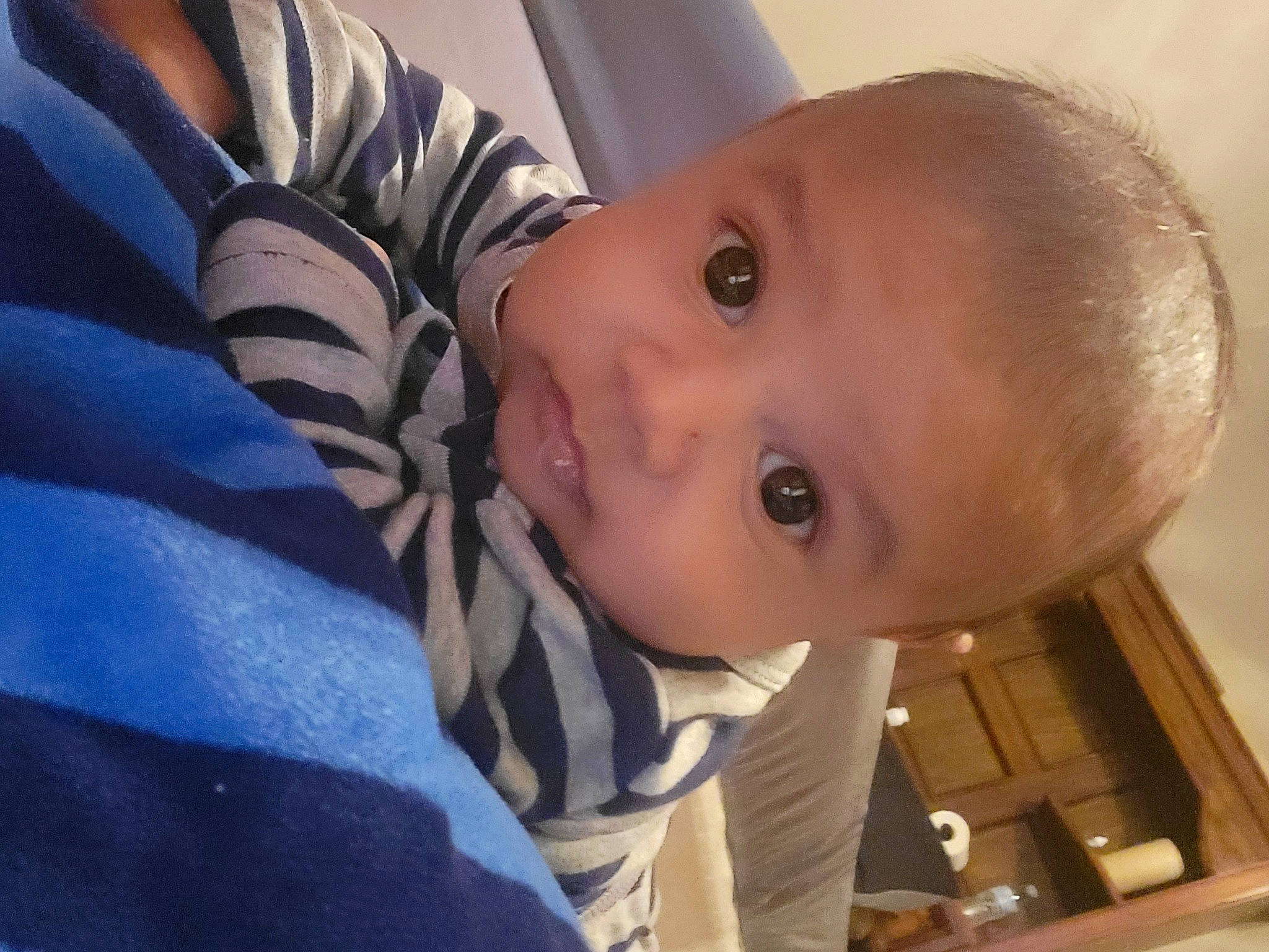 Alonso is registered to the contest to win money with this photo: baby, baby_toddler_clothing, cheek, child, comfort, electric_blue, eyebrow, eyelash, fun, happy, iris, lip, nose, outerwear, person, sitting, skin, sleeve, toddler, wood