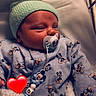 baby, beaded_chain, blanket, child, clothing, cute, face, hat, hospital, hospital_bassinet, indoor, infant, mickey_mouse, newborn, pacifier, portrait, red_heart_emoji, resting, sleeping, soft_light