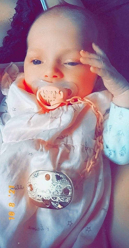 Mylèna a rejoint le concours — aidez-le/la à gagner de superbes lots ! arm, baby, baby_toddler_clothing, cheek, child, drinkware, face, facial_expression, gesture, happy, head, lip, mouth, nail, nose, person, pink, skin, sleeve, thumb