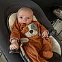 Naël a rejoint le concours — aidez-le/la à gagner de superbes lots ! baby, infant, onesie, orange_clothing, baby_rocker, face, hand, footwear, indoor, furniture, safety_strap, looking, cute, child, person, soft_toys, plush, expression, seated, comfort