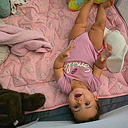 Ayanah joined the competition — help win amazing prizes! baby, child, pink_blanket, plush_toy, unicorn_pattern, onesie, smiling, happy, indoor, soft_toys, baby_girl, cute, playpen, reaching_hands, lying_down, cozy, infant, toy, face, person