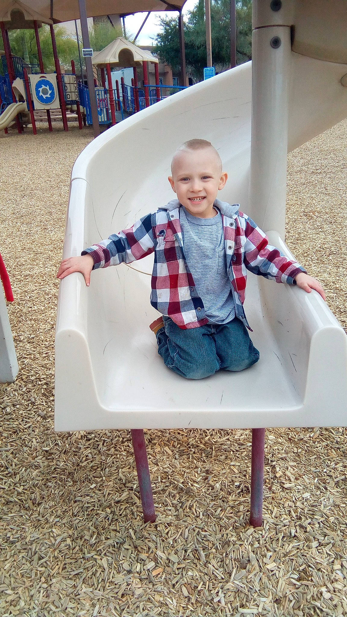 Gavyn is registered to the contest to win money with this photo: chair, child, day, design, flooring, fun, furniture, joy, outdoor_play_equipment, pattern, person, plaid, play, product, sitting, tartan, textile, toddler, vacation