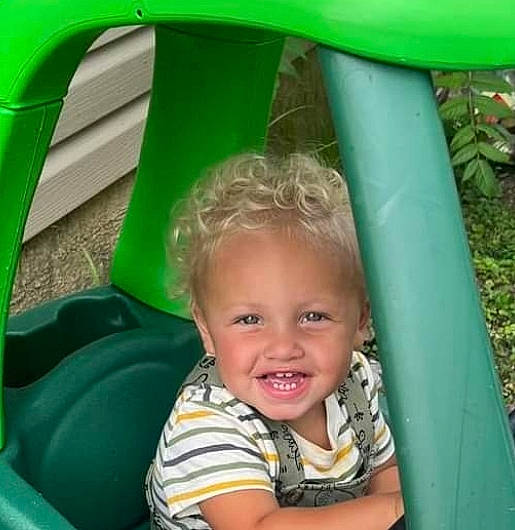 Rome is registered to the contest to win money with this photo: baby_toddler_clothing, child, chute, fun, grass, green, happy, human_settlement, joy, leisure, outdoor_play_equipment, person, photograph, playground, product, public_space, recreation, smile, snapshot, summer