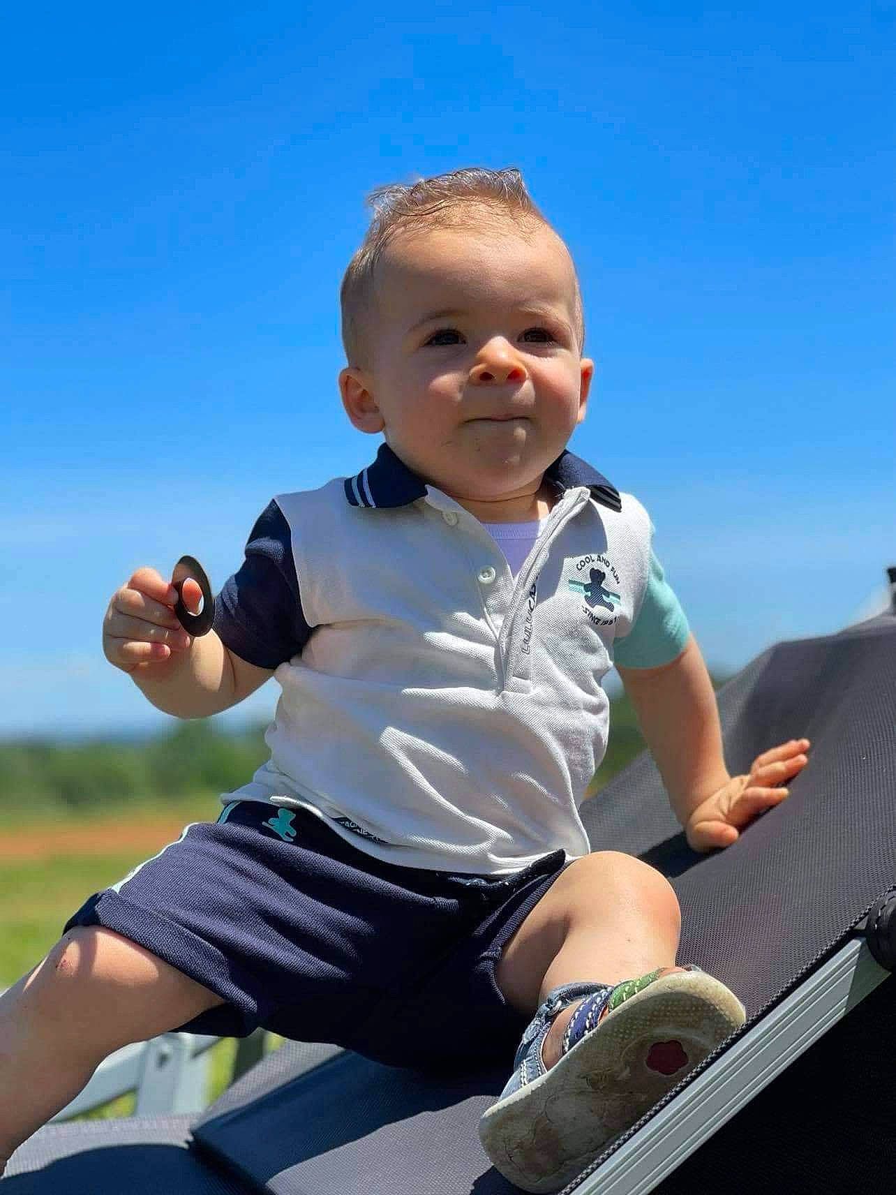 Elouan participe au concours pour gagner de l'argent avec cette photo : baby, baby_toddler_clothing, electric_blue, facial_expression, flash_photography, fun, grass, happy, human_leg, knee, leisure, people, person, recreation, shorts, sitting, sky, sleeve, smile, t_shirt