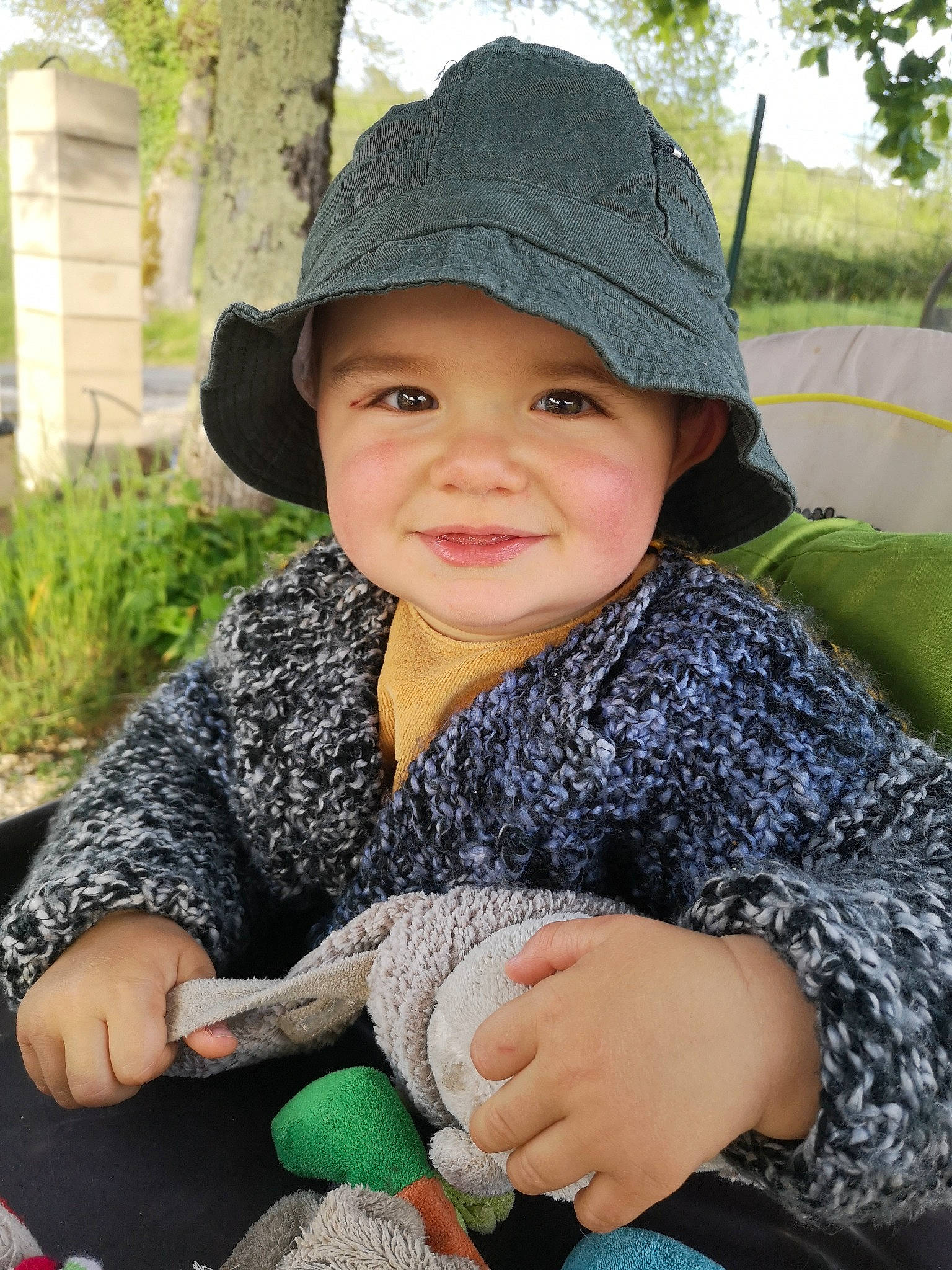 Léopold participe au concours pour gagner de l'argent avec cette photo : arm, baby, baby_toddler_clothing, cap, finger, grass, hand, happy, headwear, human_body, joy, leaf, outerwear, person, photograph, plant, product, skin, sleeve, smile