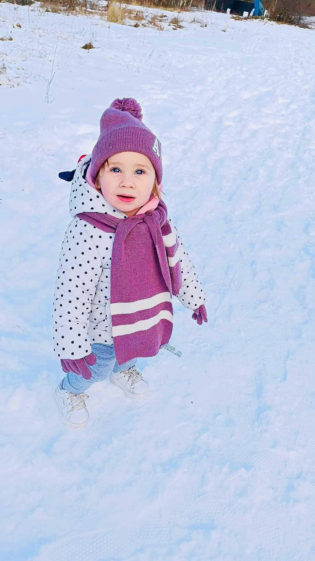 Inaya participe au concours pour gagner de l'argent avec cette photo : baby, baby_toddler_clothing, beanie, cap, child, electric_blue, freezing, fun, headwear, hood, knit_cap, magenta, pattern, people_in_nature, person, pink, play, recreation, sleeve, snow