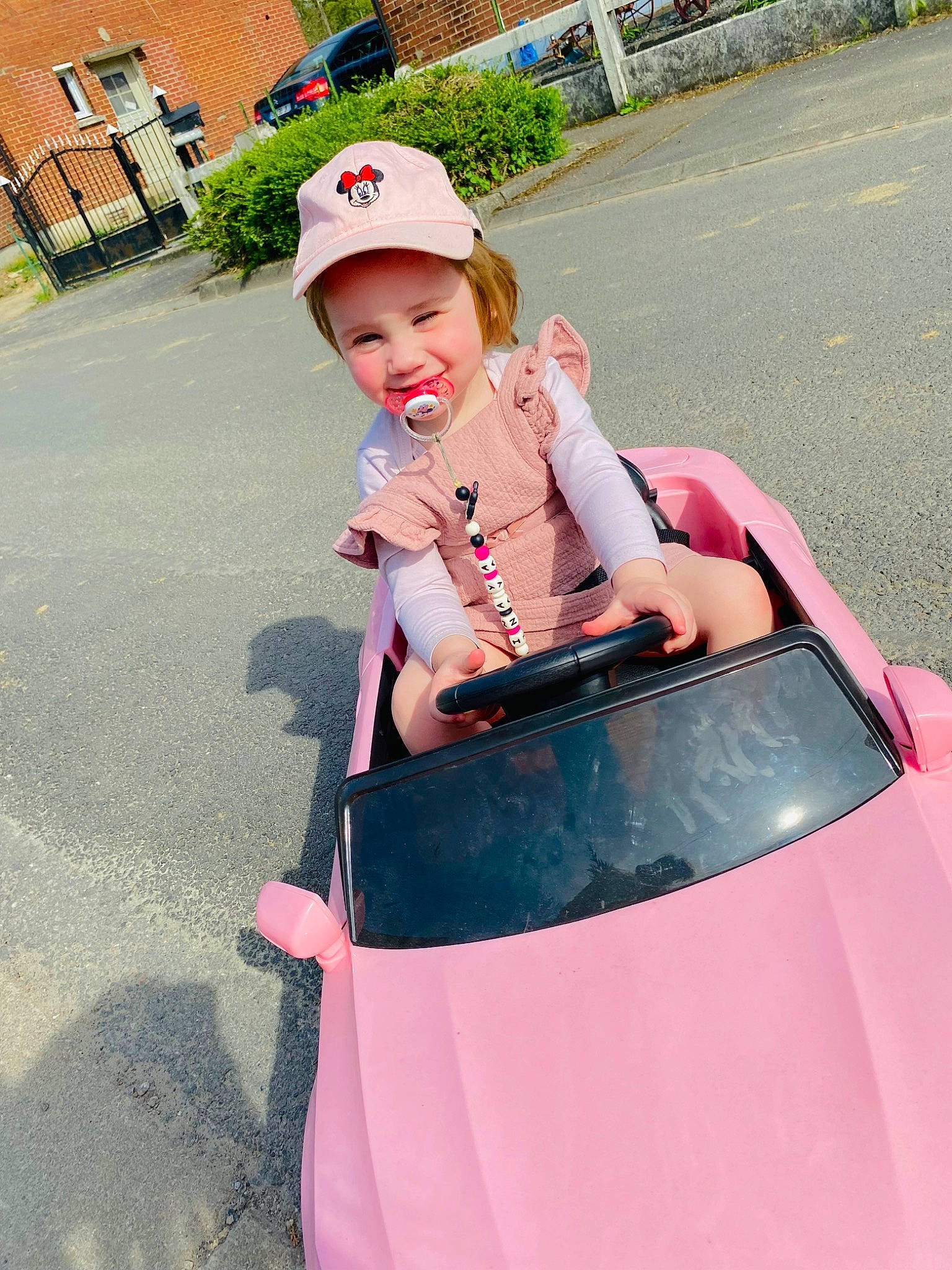 Inaya participe au concours pour gagner de l'argent avec cette photo : asphalt, auto_part, automotive_design, automotive_exterior, automotive_lighting, bumper, car, fun, grass, headwear, hood, joy, leisure, magenta, motor_vehicle, person, personal_protective_equipment, pink, plant, recreation