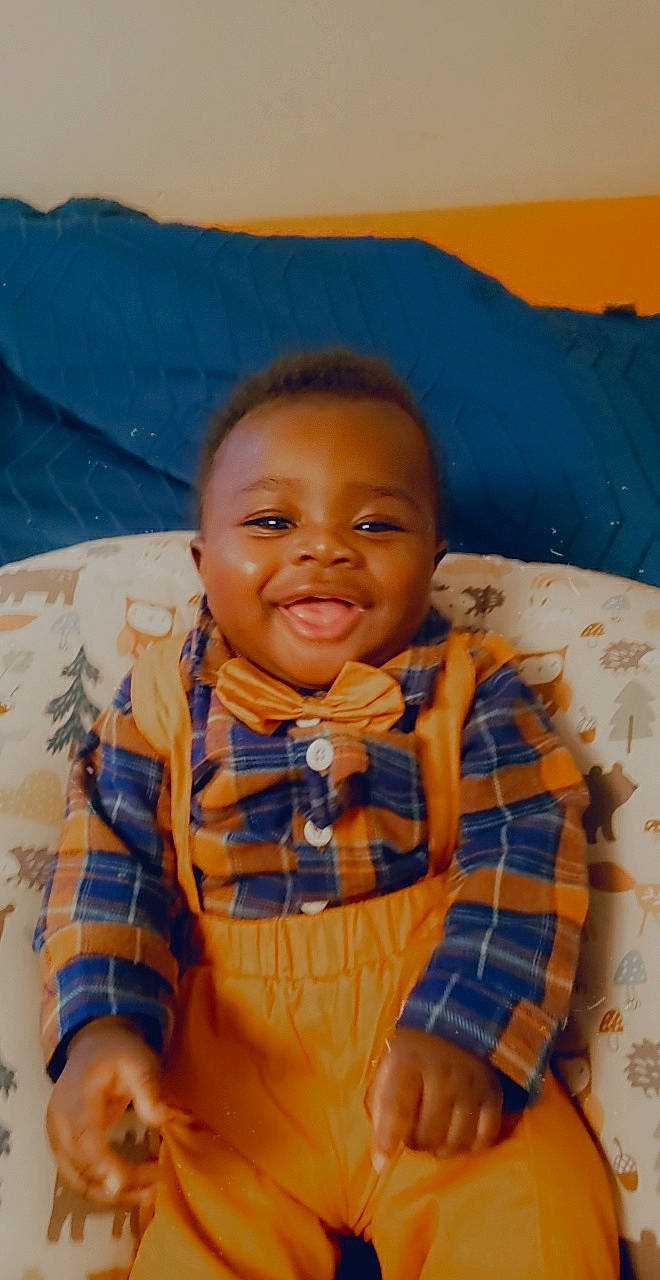 Jeremy is registered to the contest to win money with this photo: arm, baby, cheek, comfort, eye, eyebrow, forehead, fun, happy, head, iris, joy, leisure, mouth, nose, orange, person, skin, sleeve, smile