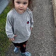 November is registered to the contest to win money with this photo: child, toddler, girl, sweatshirt, hair_clip, sidewalk, guardrail, grass, crocs, shoes, pavement, curb, outdoor, portrait, standing, expression, hair, casual, street, person