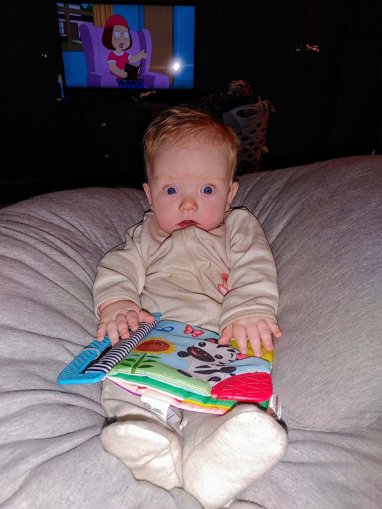 Evander joined the competition — help win amazing prizes! baby, baby_toddler_clothing, book, cable_television, cheek, child, comfort, couch, flooring, fun, iris, lap, living_room, person, play, room, sitting, television, television_set, textile