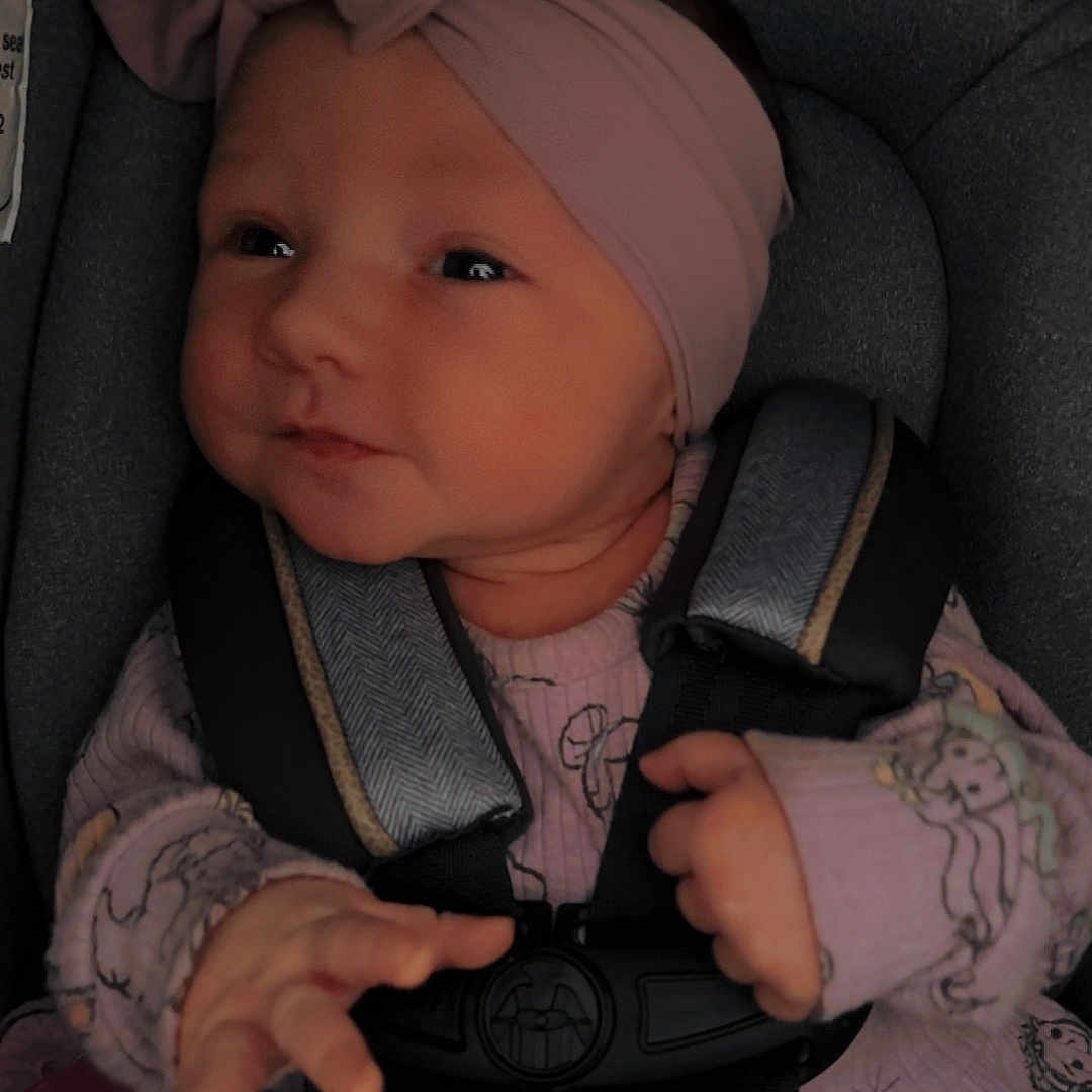 Timber is registered to the contest to win money with this photo: accessories, baby, belt, bodypart, bonnet, car, car_interior, carseat, clothing, face, finger, hand, hat, head, headband, person, skin, tattoo, transportation, vehicle