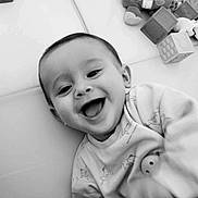 Gabin participe au concours pour gagner de l'argent avec cette photo : baby, black_and_white, child, closeup, clothing, cute, expression, face, happy, indoor, infant, joy, person, playful, portrait, smiling, soft_surface, sweater, toy, young