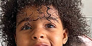 Angelina is registered to the contest to win money with this photo: child, smiling, curly_hair, face, teeth, black_tank_top, indoor, person, portrait, happy, cute, skin, young, expression, head_and_shoulders, childhood, natural_light, casual, closeup, hair