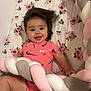 baby, smiling, infant, onesie, nike, pink, hair, cushion, braided, floral, blanket, happy, child, cute, playful, indoor, person, soft, pattern, lying