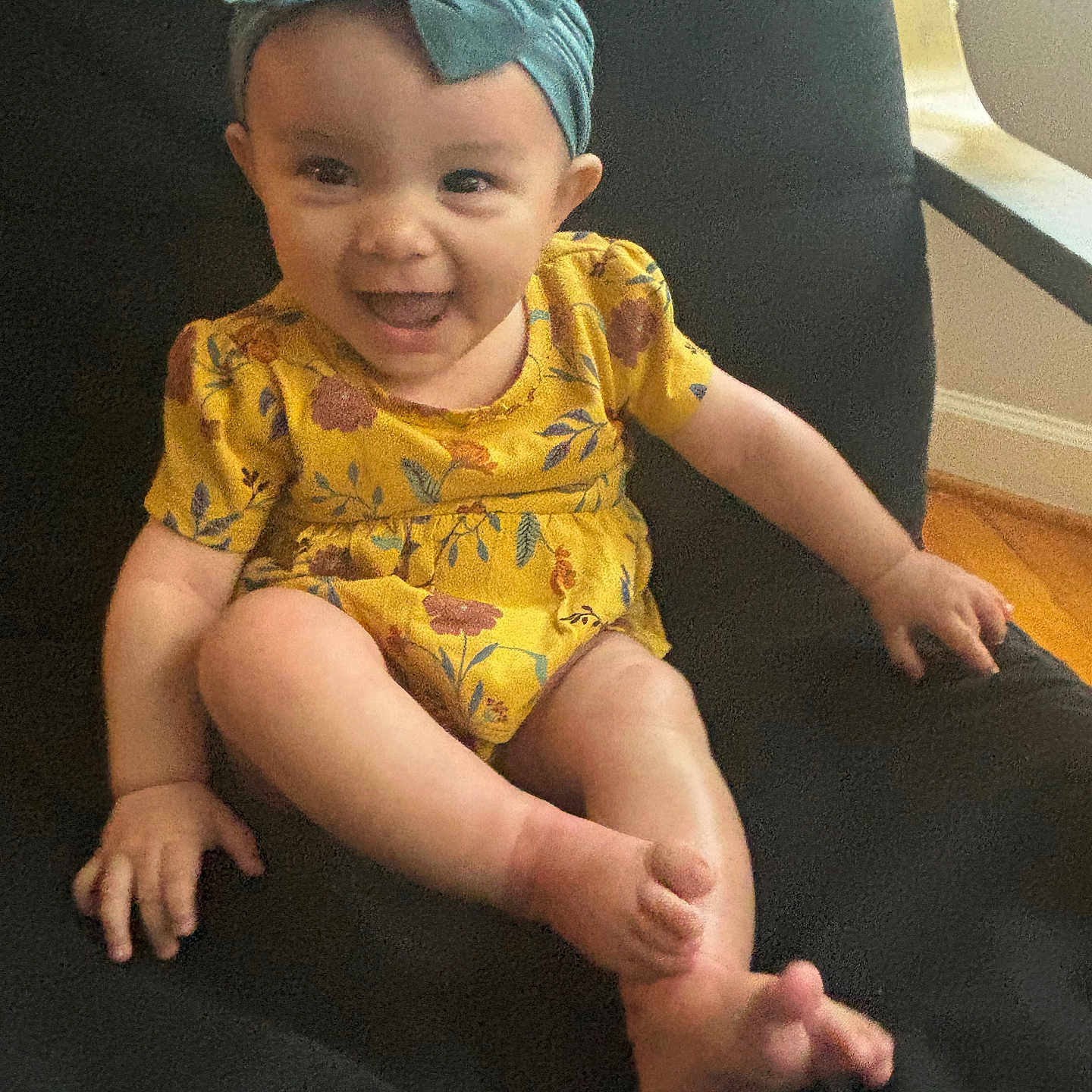 Ivy is registered to the contest to win money with this photo: accessories, baby, babylaughing, chair, clothing, couch, cushion, dress, face, furniture, happy, hat, head, homedecor, pants, person, photography, portrait, sitting, smile