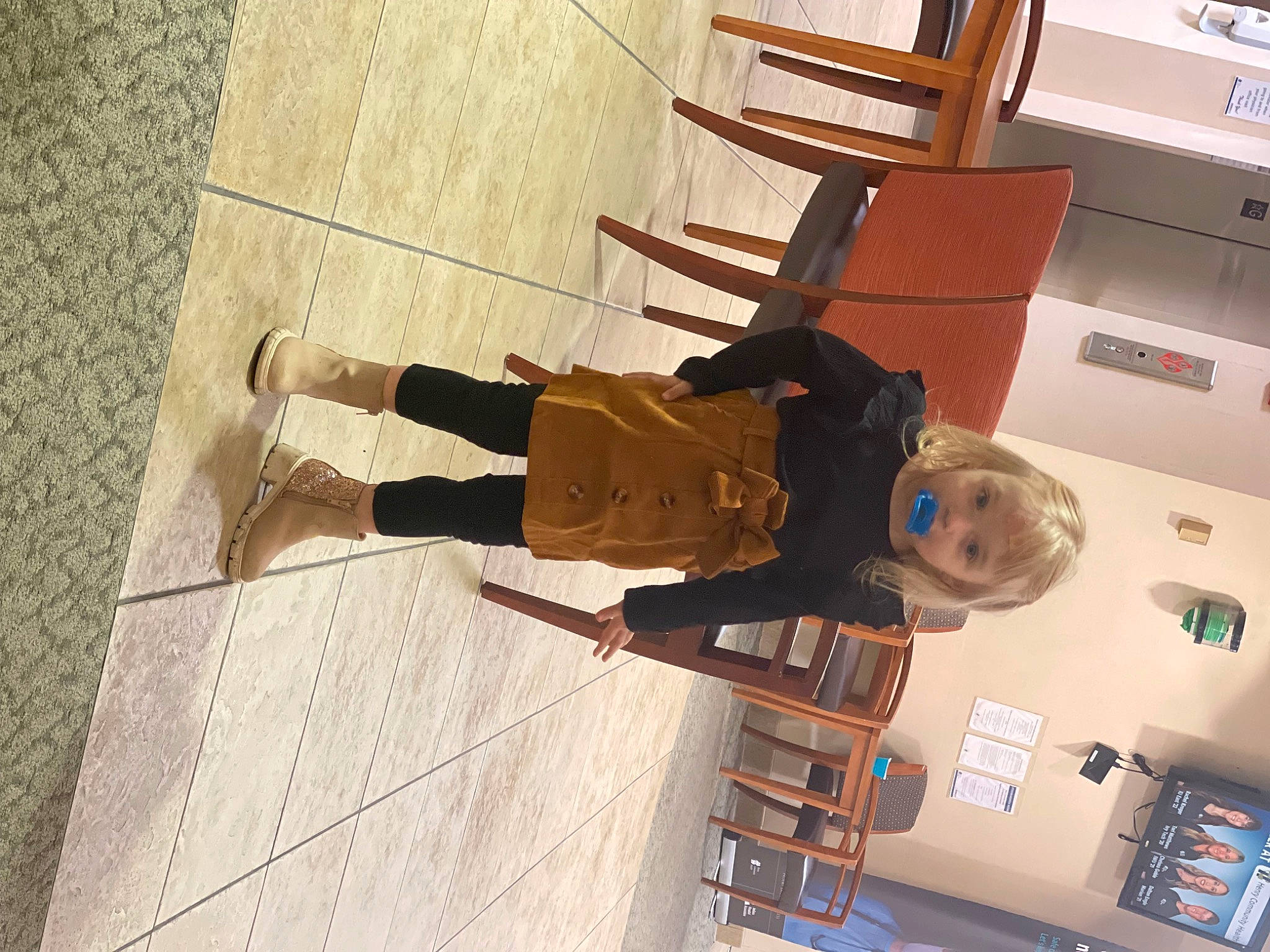 Eden is registered to the contest to win money with this photo: flooring, fun, hardwood, human_leg, machine, outdoor_shoe, person, room, shadow, shelf, smile, walking_shoe, wood