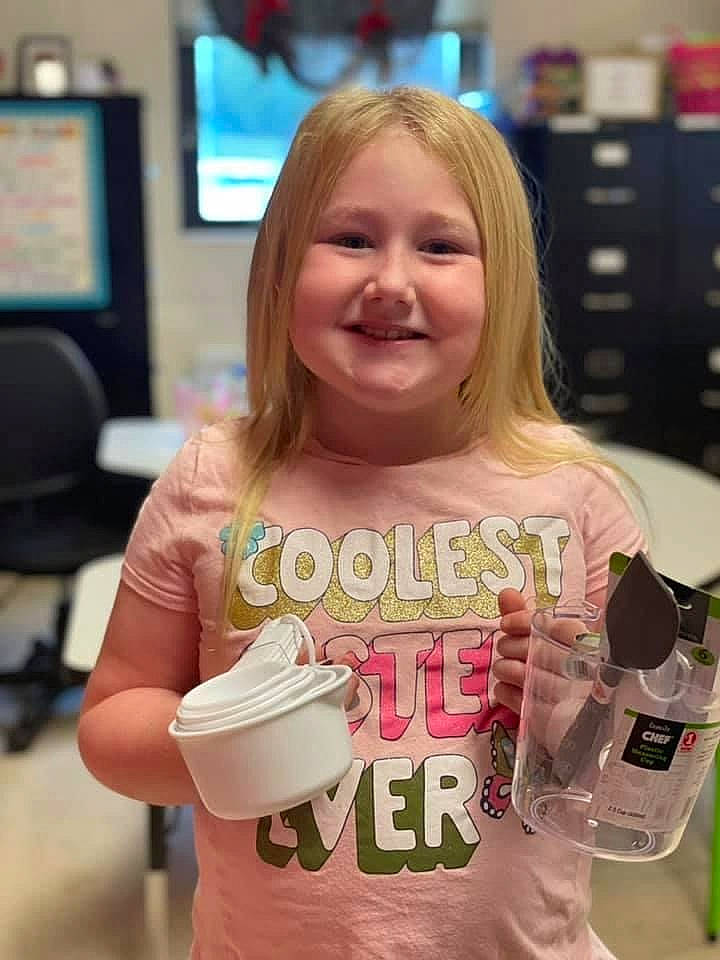 Paisleigh is registered to the contest to win money with this photo: blond, brown_hair, cabinetry, child, cup, drink, drinking, drinkware, fun, hair, happy, joy, muscle, person, plastic_bottle, sleeve, smile, summer, t_shirt, television