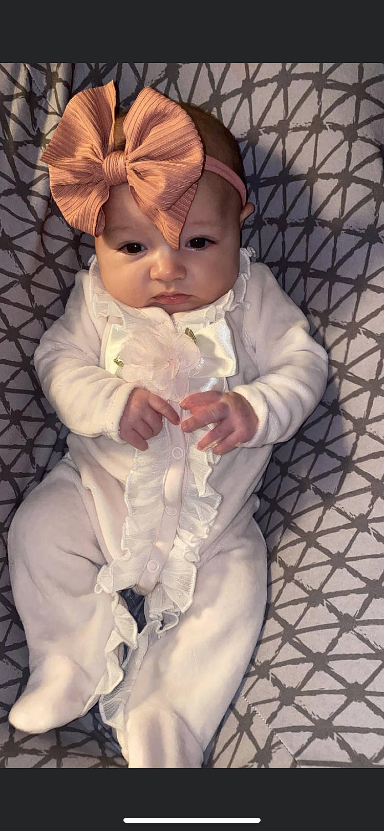 Amerila is registered to the contest to win money with this photo: baby, baby_products, baby_toddler_clothing, cheek, child, comfort, costume_hat, dress, fashion_accessory, fur, hat, headwear, linens, pattern, peach, person, petal, pink, sitting, skin