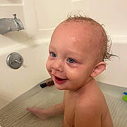 Silas is registered to the contest to win money with this photo: toddler, child, bath, bathtub, water, smile, wet_hair, happy, skin, face, ear, sitting, bathroom, plumbing_fixture, toy, infant, person, cute, playful, cleaning