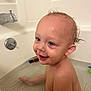 toddler, child, bath, bathtub, water, smile, wet_hair, happy, skin, face, ear, sitting, bathroom, plumbing_fixture, toy, infant, person, cute, playful, cleaning