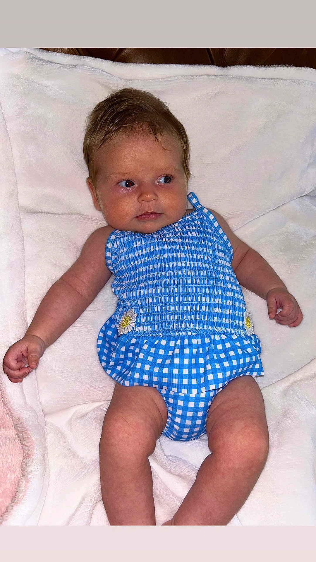 Livvy joined the competition — help win amazing prizes! baby, infant, child, blue_clothing, checkered_pattern, daisy, blanket, white_blanket, lying_down, cute, curious_expression, skin, face, arms, legs, indoors, soft_texture, newborn, one_person, portrait