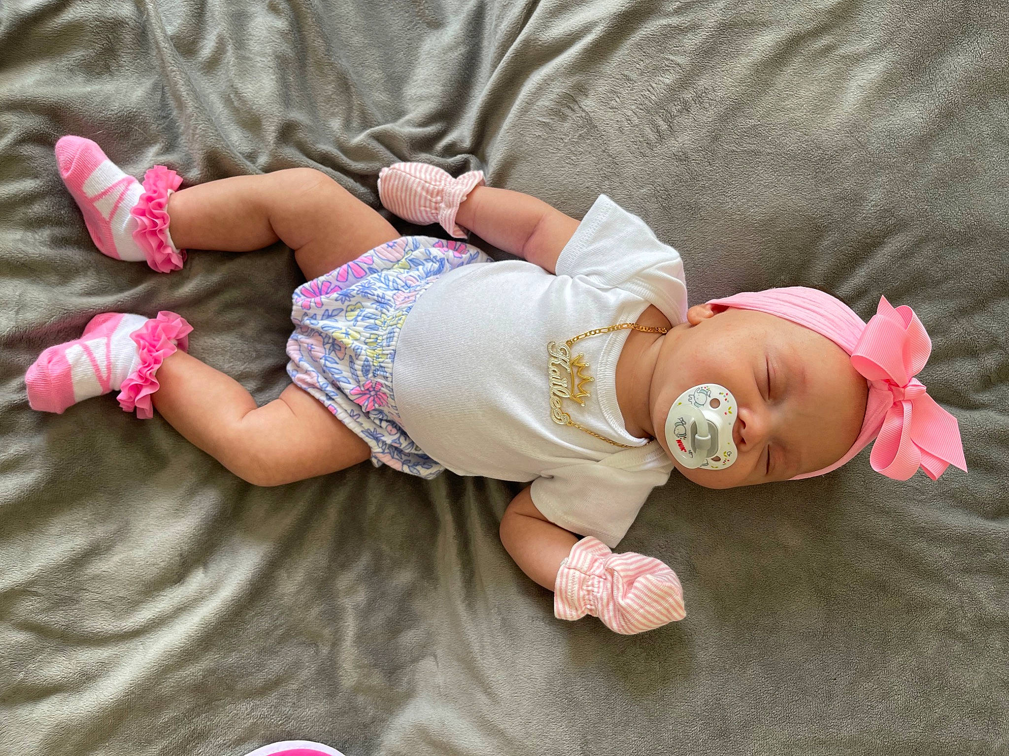 Kailee is registered to the contest to win money with this photo: arm, baby, baby_toddler_clothing, comfort, dress, finger, foot, glasses, grass, hand, hat, human_body, leg, person, pink, skin, sleeve, sock, sunglasses, thigh