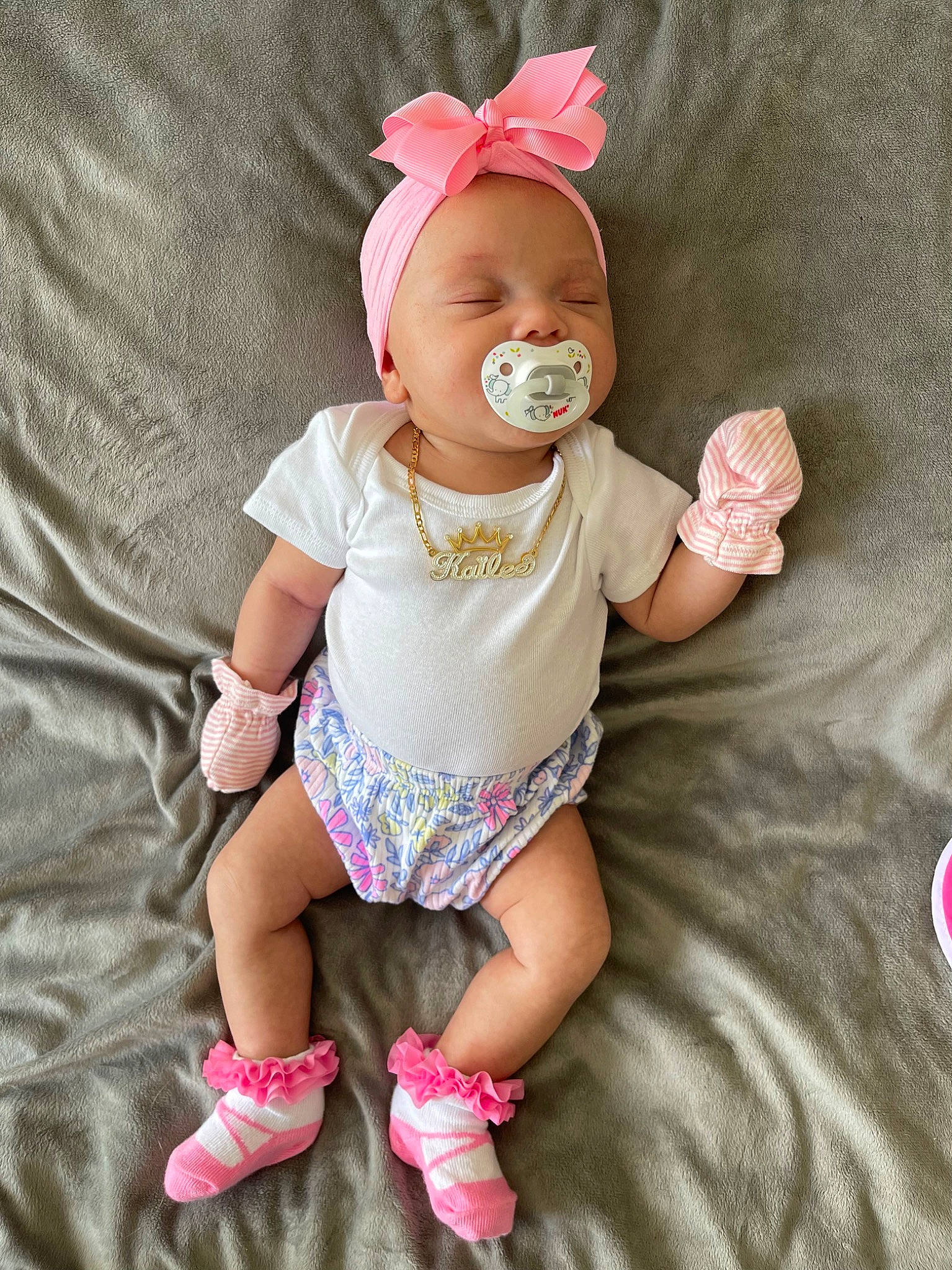 Kailee joined the competition — help win amazing prizes! baby, baby_toddler_clothing, child, comfort, fashion_accessory, grass, happy, hat, human_leg, knee, magenta, pattern, person, pink, sitting, skin, sleeve, smile, sock, thigh