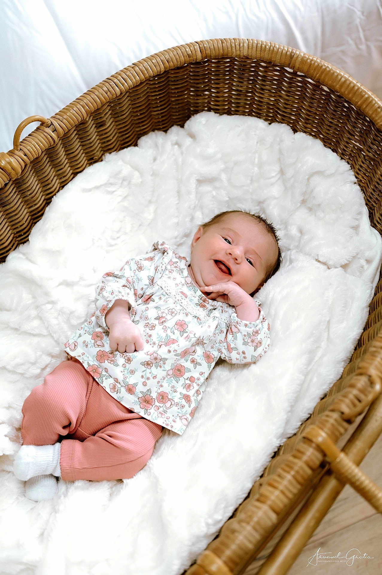 Judith participe au concours pour gagner de l'argent avec cette photo : baby, smiling, wicker_basket, blanket, floral_clothing, pink_pants, white_socks, infant, happy, cozy, indoor, cute, newborn, portrait, resting, soft_texture, child, person, warm, relaxed