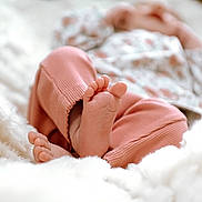 Judith a rejoint le concours — aidez-le/la à gagner de superbes lots ! baby, feet, pink_pants, soft, blanket, cozy, infant, closeup, blurred_background, cuteness, warmth, relaxing, sleeping, comfort, skin, toes, texture, bed, soft_lighting, rest