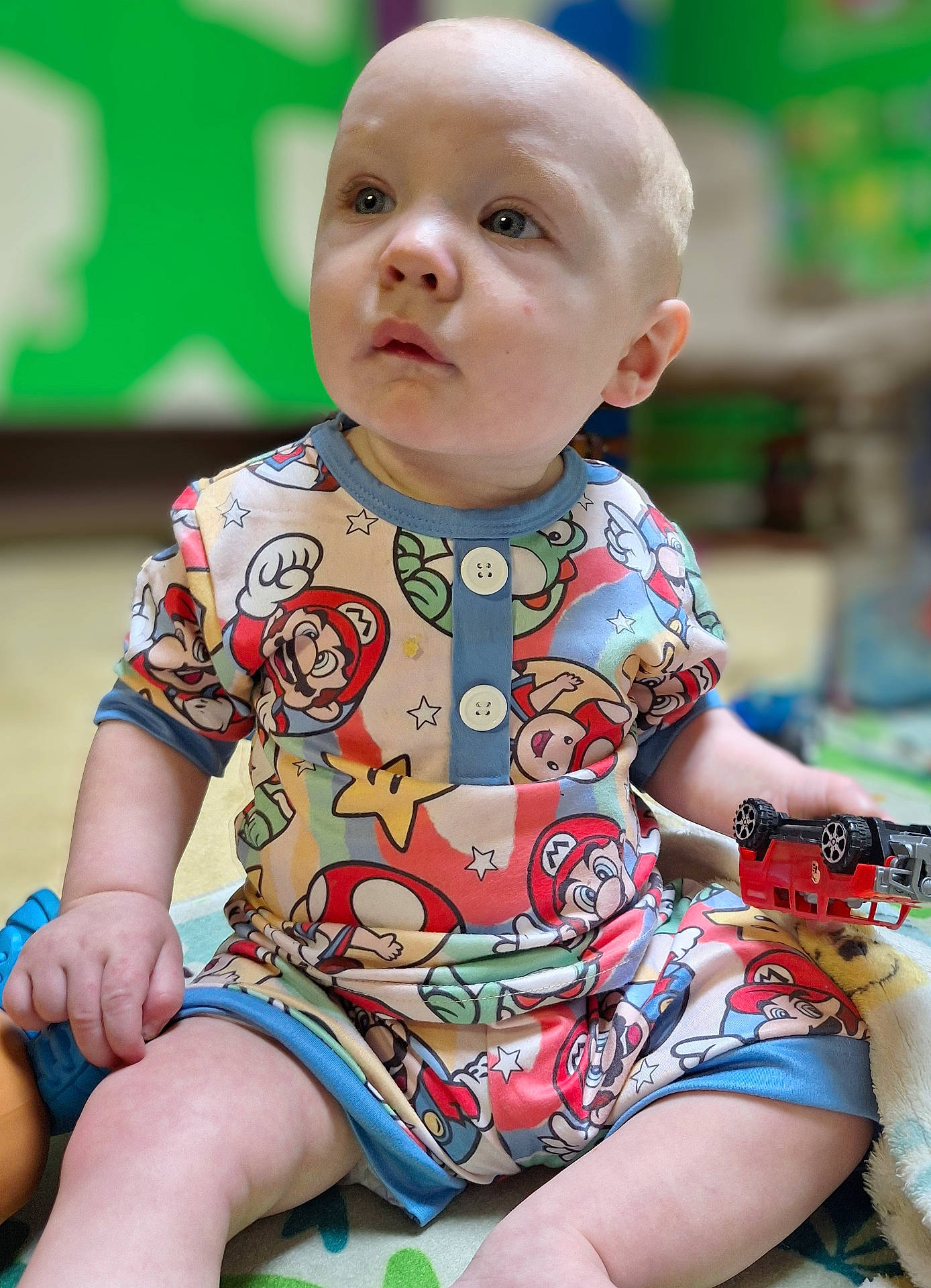 Kaladin is registered to the contest to win money with this photo: applique, baby, bodypart, clothing, couch, face, finger, furniture, gun, hand, head, pattern, person, photography, portrait, shorts, sitting, t_shirt, toy, weapon