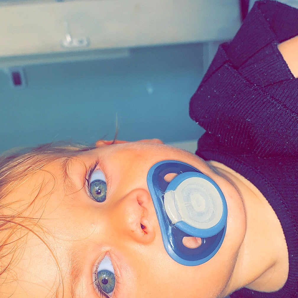 Bonnie-Rae joined the competition — help win amazing prizes! baby, bed, blanket, blue_eyes, child, close_up, ear, face, hair, head, indoors, infant, mouth, nose, pacifier, patterned_wall, person, resting, skin, sweater