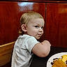 Daxton Kole joined the competition — help win amazing prizes! casual_clothing, child, curly_hair, cute, face, food, indoor, looking_back, meal, messy_face, plate, restaurant, sitting, smile, table, toddler, white_shirt, wood_paneling, wooden_chair, young_child