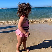 Kehlani is registered to the contest to win money with this photo: toddler, child, beach, sand, ocean, water, waves, sunny, swimsuit, pink, curly_hair, shadow, barefoot, summer, outdoor, coast, playful, vacation, nature, sky