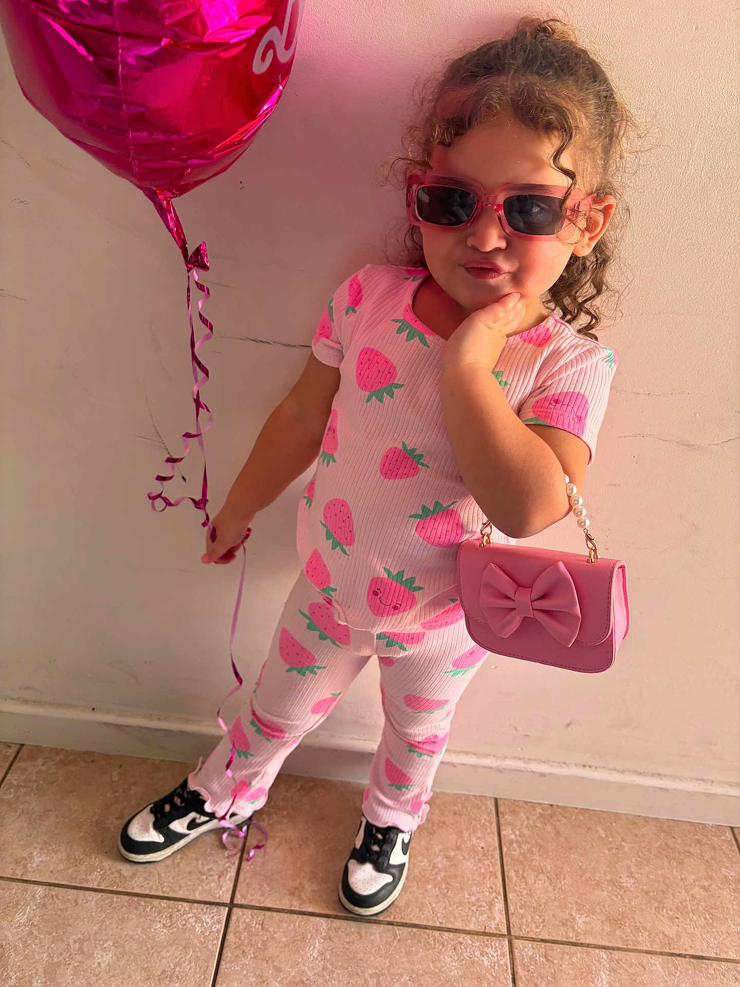 Kehlani is registered to the contest to win money with this photo: child, girl, pink, pajamas, strawberries, balloon, sunglasses, handbag, floor, wall, tile, cute, fashion, pose, standing, footwear, sneakers, curly_hair, indoor, playful