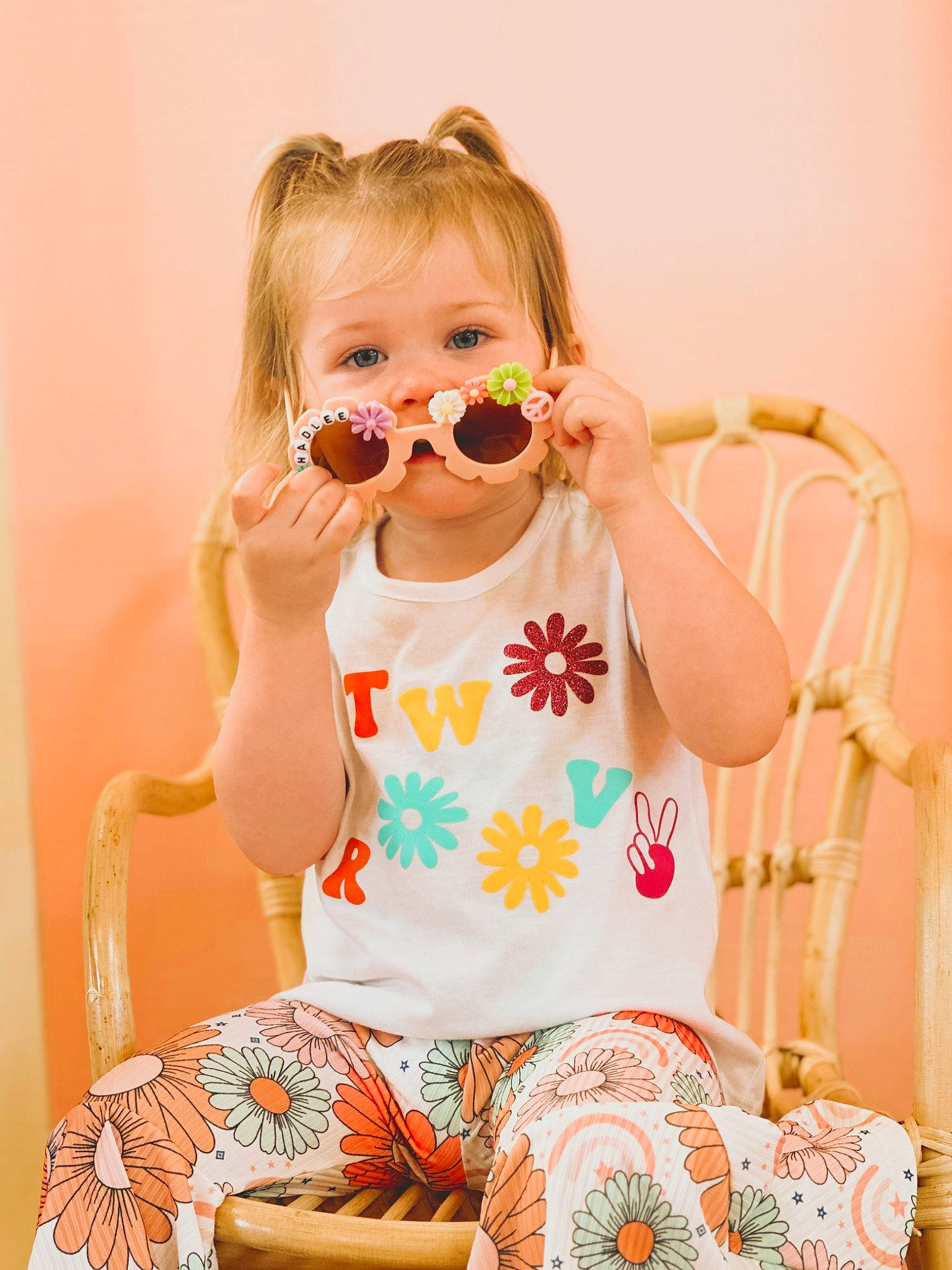 Hadlee joined the competition — help win amazing prizes! baby, baby_toddler_clothing, blond, dress, eyewear, finger, glasses, goggles, happy, neck, orange, pattern, person, pink, skin, sleeve, sunglasses, t_shirt, thigh, toddler