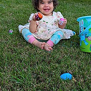 Cataleya is registered to the contest to win money with this photo: toddler, child, grass, outdoor, toy, easter_egg, basket, happy, smiling, curly_hair, barefoot, colorful, play, spring, nature, person, sitting, cute, holiday, fun