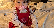 Cataleya joined the competition — help win amazing prizes! toddler, child, pacifier, headband, bow, red_dress, heart_design, bed, blanket, socks, indoors, portrait, cute, curly_hair, soft_lighting, cozy, person, baby, sitting, homedecor