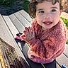 Cataleya is registered to the contest to win money with this photo: toddler, child, smile, curly_hair, pink_jacket, bench, outdoor, sunlight, happy, clapping, face, person, cute, playful, daylight, park, clothing, young_child, expression, sitting