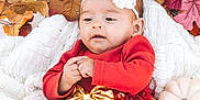 Ariella joined the competition — help win amazing prizes! baby, child, infant, red_dress, gold_bow, headband, white_flower, blanket, autumn_leaves, pumpkin, fall_theme, cozy, cute, portrait, indoors, seasonal, festive, warm_colors, baby_clothing, small_hands