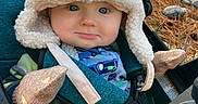 Jade joined the competition — help win amazing prizes! baby, babywearing, blue_eyes, child, clothing, cute, daylight, forest, hat, infant, mittens, nature, outdoor, person, portrait, seatbelt, smile, stroller, trees, warm_clothing