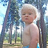 Jade is registered to the contest to win money with this photo: blond_hair, blue_eyes, child, curious, cute, daylight, forest, grass, nature, outdoor, pine_trees, playful, portrait, shirtless, sky, summer, sunlight, toddler, trees, young_child