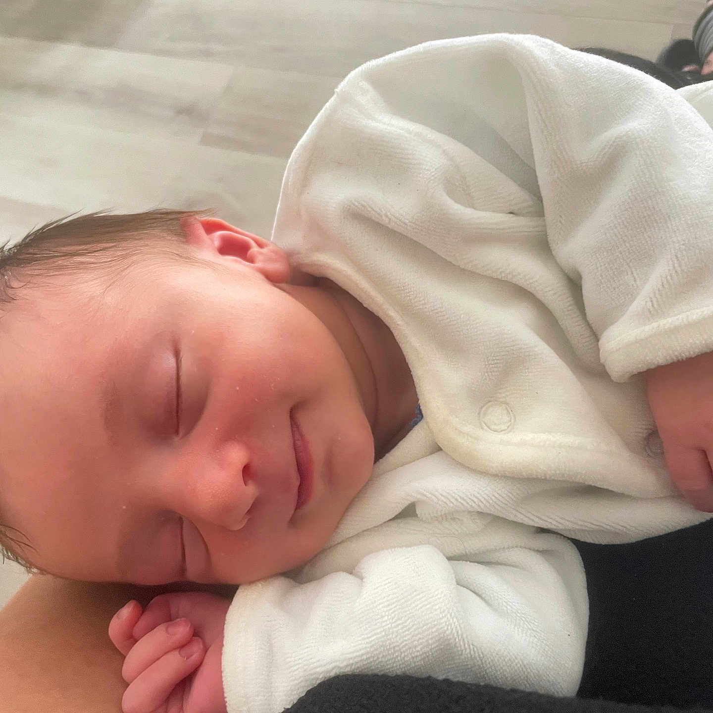 Mathy a rejoint le concours — aidez-le/la à gagner de superbes lots ! baby, closed_eyes, cute, face, floor, hand, human, indoors, infant, newborn, peace, peaceful, portrait, resting, skin, sleeping, small, smile, soft_texture, white_clothing
