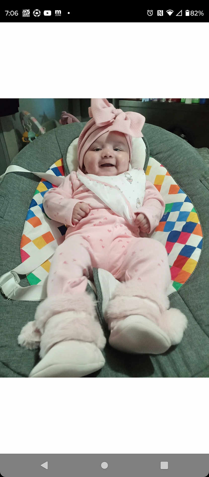 Journey is registered to the contest to win money with this photo: baby, infant, pink_clothing, headband, bow, booties, smile, baby_seat, colorful_pattern, indoor, happy, child, cute, baby_accessories, soft_toys, fabric, portrait, cozy, newborn, person