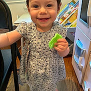 Dylan is registered to the contest to win money with this photo: toddler, child, smiling, dress, barefoot, toy, leaf, indoor, rug, floor, books, furniture, window, happy, person, portrait, young_child, playroom, wood_floor, cute