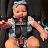 baby, blue_eyes, denim_bow, car_seat, black_straps, infant, cute, chubby_arms, headband, happy, child, sitting, clothing, closeup, indoor, safety_harness, smiling, person, cute_expression, adorable