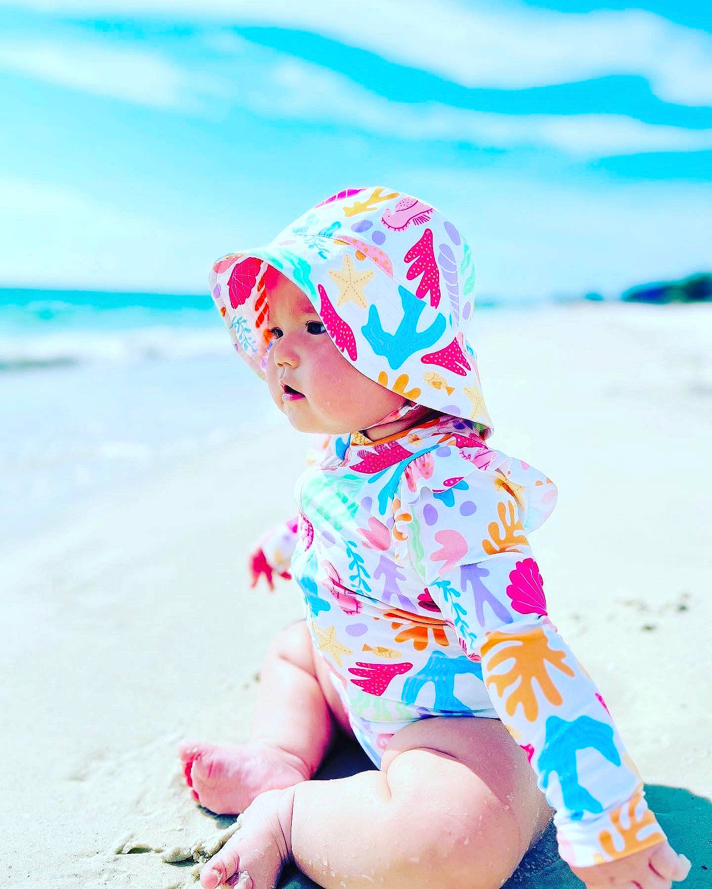 Sofia is registered to the contest to win money with this photo: baby_toddler_clothing, beach, body_of_water, dress, electric_blue, fun, happy, headgear, headwear, horizon, human_leg, landscape, leisure, magenta, people_in_nature, person, pink, sand, sky, sleeve