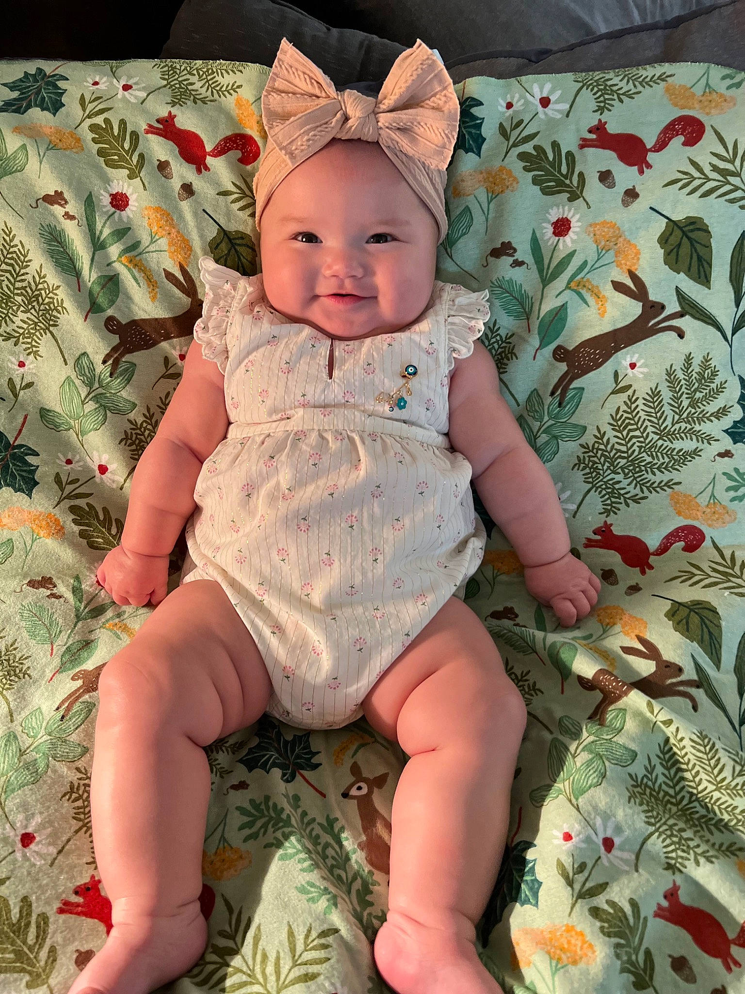 Sofia is registered to the contest to win money with this photo: baby, baby_toddler_clothing, cap, cheek, child, dress, eye, grass, happy, head, headwear, lap, linens, pattern, person, pink, skin, sleeve, smile, textile