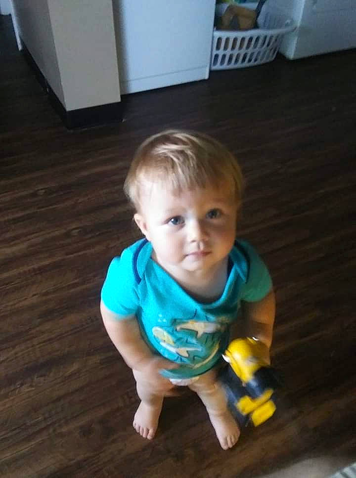 Haden is registered to the contest to win money with this photo: baby, child, eye, face, floor, flooring, fun, hardwood, head, leg, person, play, product, sitting, skin, smile, standing, toddler, toy, wood